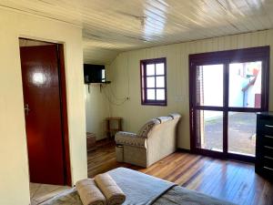 坎巴拉Central Chalés的客房设有床、沙发和窗户。