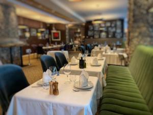 多布里奇伊兹达公园酒店 的餐厅配有白色桌椅和酒杯