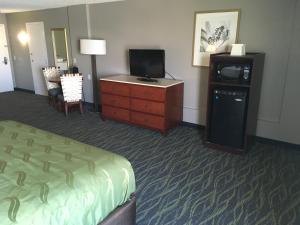 奥兰多Quality Inn & Suites Winter Park Village Area的酒店客房,配有床和电视