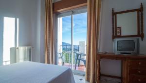 兰哈龙安达卢西亚酒店的一间卧室配有一张床、一台电视和一个阳台