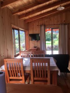 Los QueñesLos Quenes River Lodge的一间带桌椅和窗户的用餐室