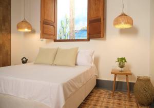 圣玛尔塔Casa Rosa - Alma Hotels的一间卧室配有一张带窗户和桌子的床