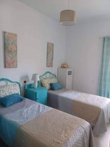 马萨尔福恩Lucky Summer Marsalforn Holiday Apartment的一间卧室配有两张蓝色和白色的床