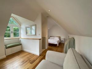 阿斯顿尖塔Candlewick Cottage的阁楼客厅配有沙发和1张床