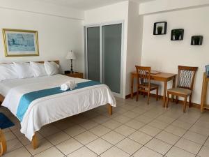 危地马拉雷佛马公寓式酒店的卧室配有一张床和一张桌子及椅子