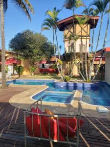 瓜拉雷马Hotel Beira Rio Guararema的一个带游泳池和棕榈树的度假村