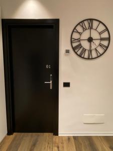 福贾IL TIGLIO VERDE的墙上挂着时钟的黑色门