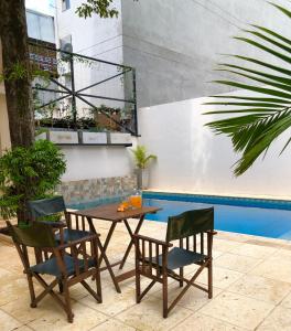 波萨达斯Edificio Itasu - 3ro - alquileres temporales的一张桌子和两把椅子以及一个游泳池