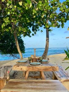 图鲁斯杜Samura Panorama Guest House的海滩上的野餐桌,享有海景