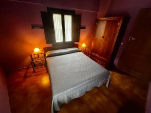 埃尔瓦La Estrella de David, Apartamentos Rurales的一间卧室配有一张带窗户和两盏灯的床。