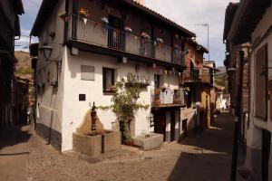 埃尔瓦La Estrella de David, Apartamentos Rurales的阳台上的小巷,有鲜花建筑