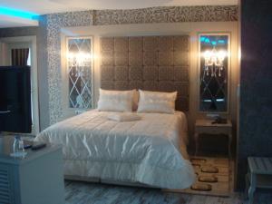 瑟奇科伊金帕拉斯酒店 的一间卧室设有一张大床和两个窗户。