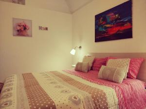 莫尔费塔La Maison apartment的一间卧室配有一张大床,铺有粉色和白色的床单。