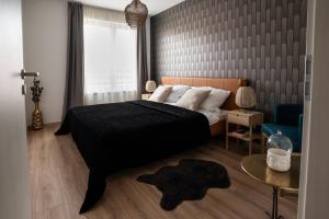 索普隆Cesar Apartman的一间卧室配有黑色的床和蓝色椅子