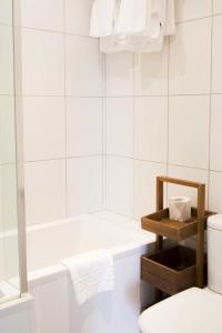 圣马丁格恩西Les Douvres Hotel的白色的浴室设有浴缸和卫生间。