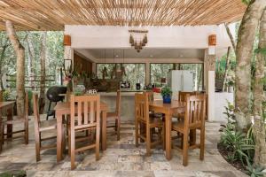 图卢姆Cachito de Cielo Luxury Jungle Lodge的厨房以及带桌椅的用餐室。