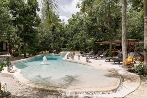 图卢姆Cachito de Cielo Luxury Jungle Lodge的庭院中一个带喷泉的游泳池