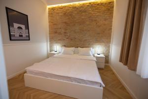 蒂米什瓦拉Carol Residence的一间卧室设有一张床和砖墙