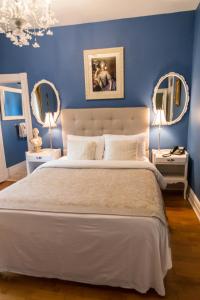 Bécancour贝肯考特庄园酒店的一间卧室设有蓝色的墙壁和一张带两面镜子的床