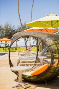 卡帕阿考伊海滩酒店的度假村的秋千配有椅子和遮阳伞