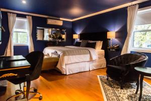 Bécancour贝肯考特庄园酒店的卧室配有一张床、一张桌子和椅子