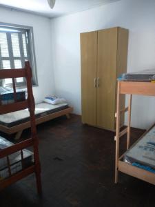 阿雷格里港Hostel Cachoeira的客房设有两张双层床和木制橱柜。