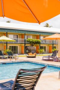 卡帕阿考伊海滩酒店的游泳池,带椅子和遮阳伞