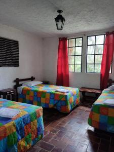科万Posada Montaña del Quetzal的一间卧室设有两张床和两个窗户。