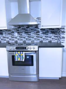 InnisfilWELCOME TO PREMIUM LIVING PLACE / 2 BEDROOMS SUITE的厨房配有不锈钢炉灶和白色橱柜。