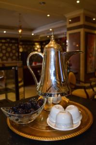 麦地那路塔纳奥迈斯克酒店的茶壶和桌子上的一碗浆果