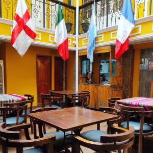 拉巴斯Wake Up Hostel的餐厅设有木桌和墙上的旗帜