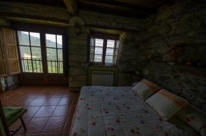 BoalA Casua的石屋设有窗户,卧室配有床