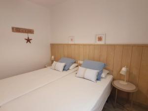帕拉莫斯Palamós Apartament Superior Garoina的一间卧室配有两张带蓝白色枕头的床