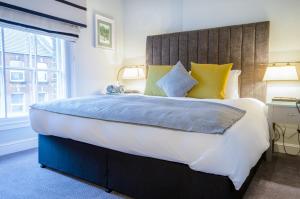 伦敦图尔斯山酒店的一间卧室配有一张大床,提供黄色和蓝色的枕头