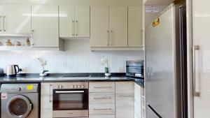 绍斯布鲁姆San Lameer Style by Top Destinations Rentals的厨房配有白色橱柜和不锈钢冰箱