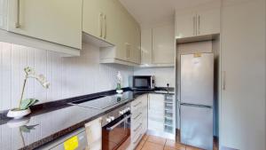 绍斯布鲁姆San Lameer Style by Top Destinations Rentals的厨房配有白色橱柜和冰箱。