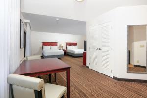 圣玛丽亚Holiday Inn & Suites Santa Maria, an IHG Hotel的一间带餐桌的房间和一间卧室