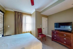 德斯坦Emerald Grande 324的一间卧室配有一张床和一台平面电视