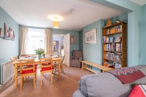 莱斯顿40 Buller Road - Aldeburgh Coastal Cottages的客厅配有桌椅和书架