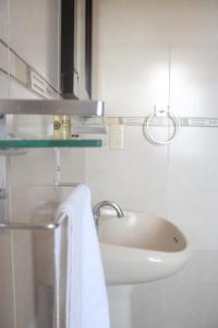萨卡特卡斯Hotel Alika的白色的浴室设有水槽和毛巾