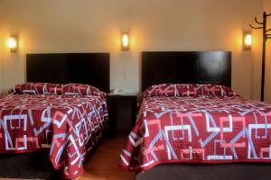 萨卡特卡斯Hotel Alika的酒店客房,配有两张带红白毯子的床