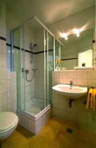 吕贝克旅行者酒店的带淋浴、盥洗盆和卫生间的浴室
