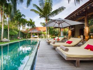 坎古Villa Desa Roro Dua的一个带躺椅和遮阳伞的度假游泳池