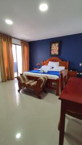 巴兰基亚Hotel Dorado Barranquilla的一间卧室设有两张床和蓝色的墙壁