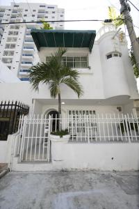 卡塔赫纳Apartamento en Casa Dandy的白色的房子,有白色的大门和棕榈树