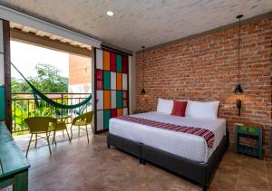 比亚维森西奥NQ Hotel Orinoquia的一间卧室设有一张床和砖墙