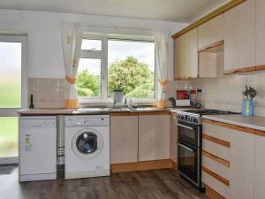 CoundonHaweswater Cottage的厨房配有洗衣机和窗户。