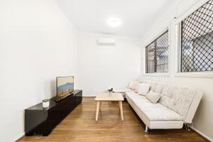 悉尼4 Bedroom house 500M to Drummoyne Bay Run的白色的客厅配有沙发和桌子