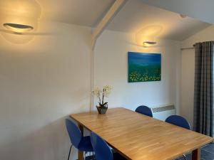 IfoldThe Lodge At The Lake House的一间带木桌和蓝色椅子的用餐室