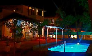卡兰古特GR Stays WHITE HOUSE 4bhk Private Pool Villa in Calangute的夜间在房子前面的游泳池